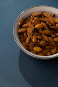 Close-up of soaked almonds in a white bowl, perfect for vegan and healthy food concepts.